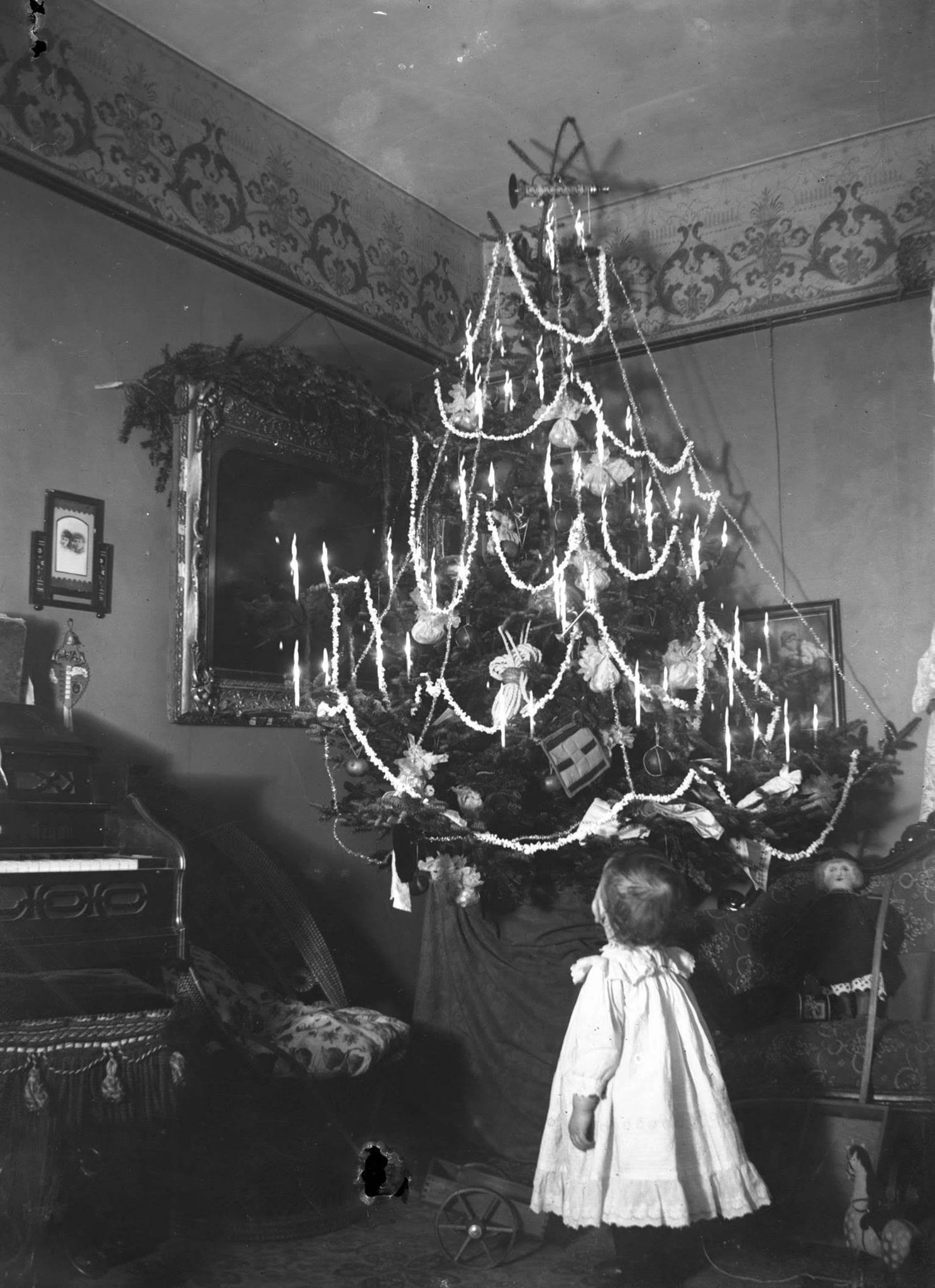 This is a very rare photo of an indoor Christmas tree in 1905 taken in Bloomfield Station, New Brunswick. The child is a two year old Ronald Hayes in his parents house. Provincial Archives of New Brunswick P39\1